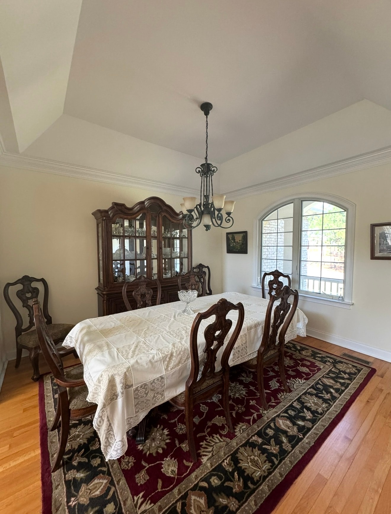 Dining room before listing-ready refresh — formal table, china cabinet, arched window