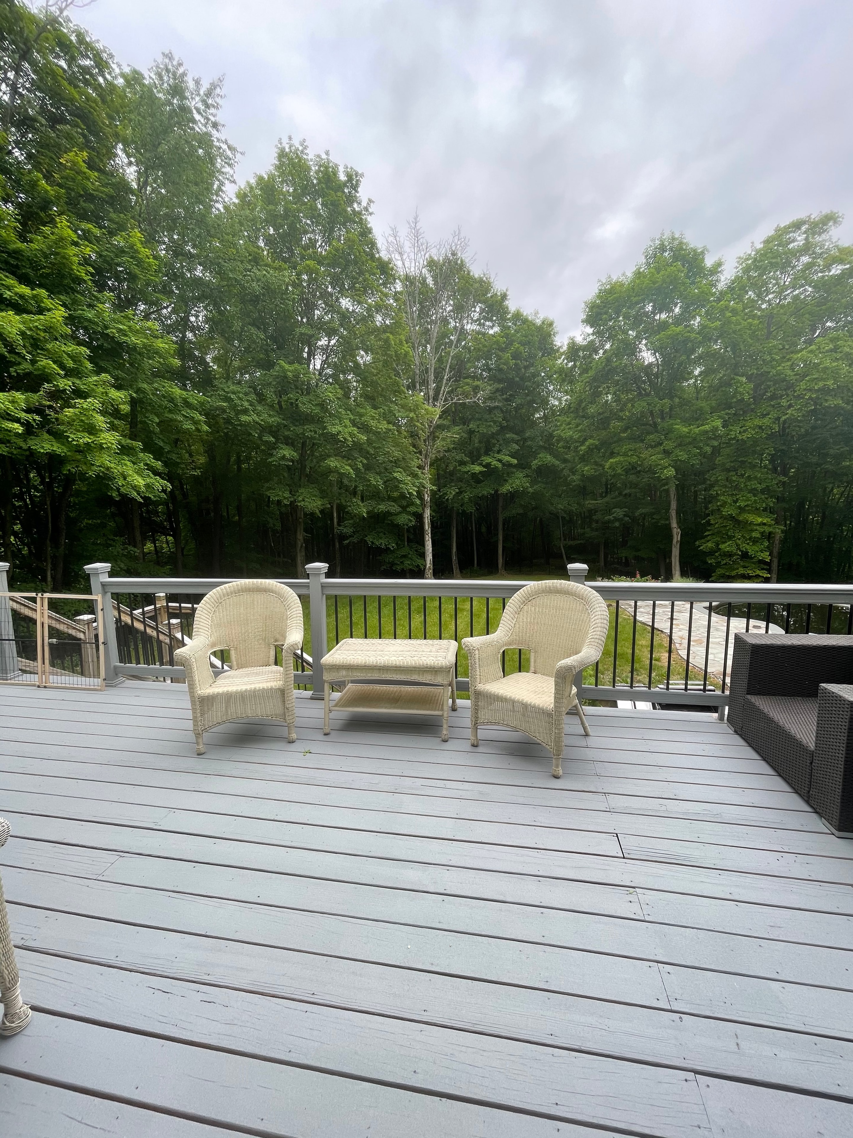Grey deck before redesign — wicker chairs, dated railings