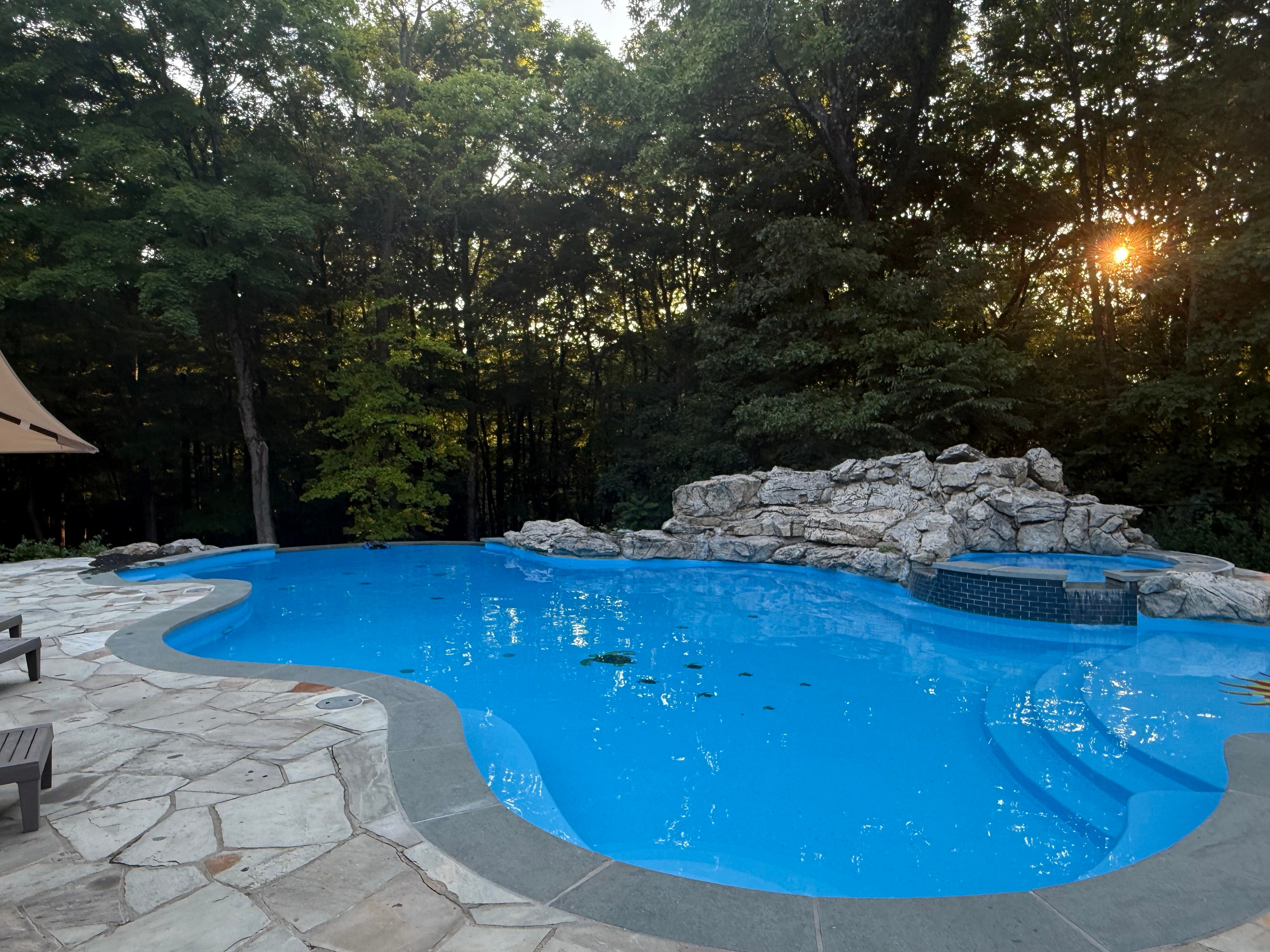 Pool after renovation — bright blue water at sunset