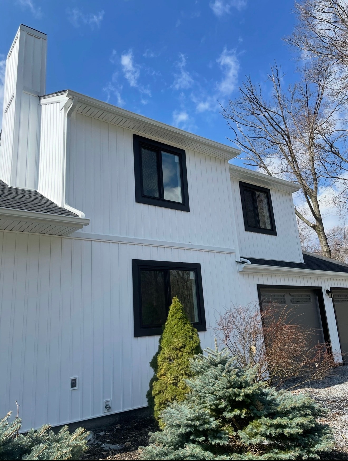 White house close-up — new siding and black windows